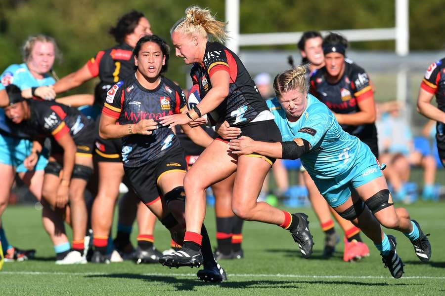 Grace Steinmetz (C) is tackled during a match