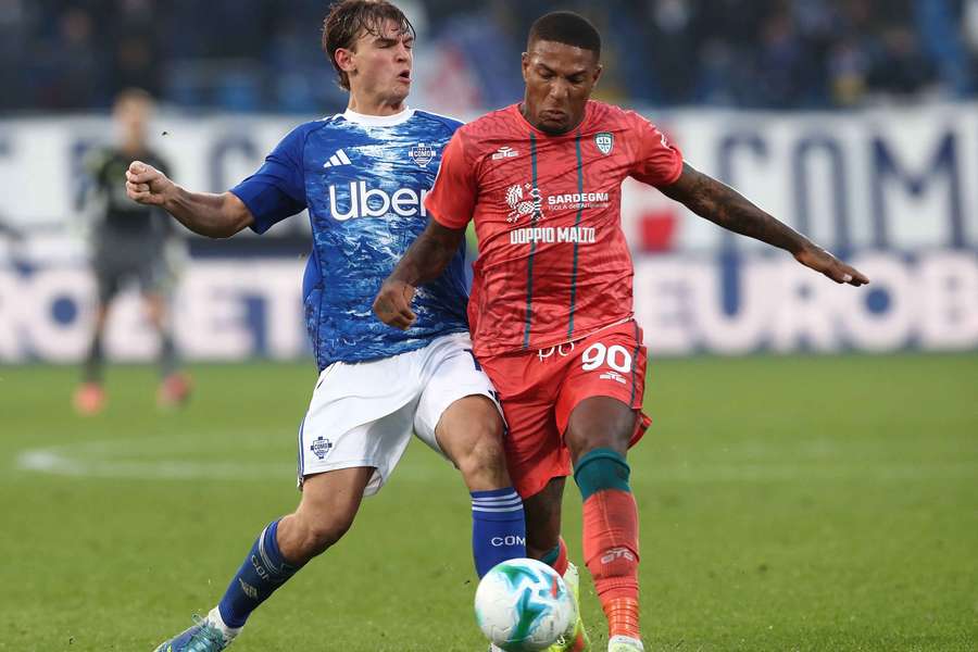 Nico Paz z Coma (vlevo) v souboji s Folorunshou z Cagliari.