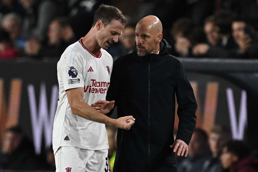 Northern Irish defender #35 Jonny Evans (L) speaks with Manchester United's Dutch manager Erik ten Hag