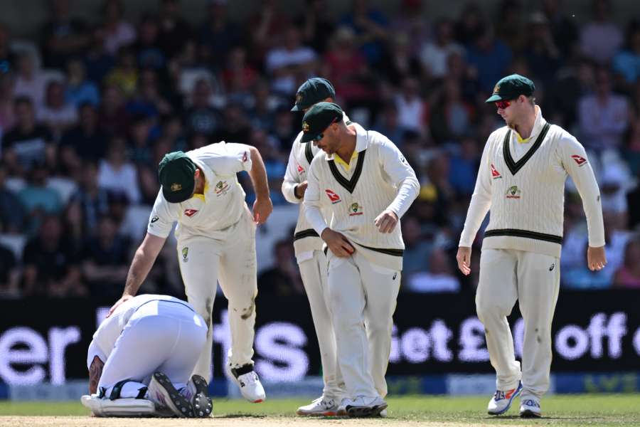 Australia's Mitchell Marsh (2L) consoles England's captain Ben Stokes (L) as he suffers after being hit by a ball