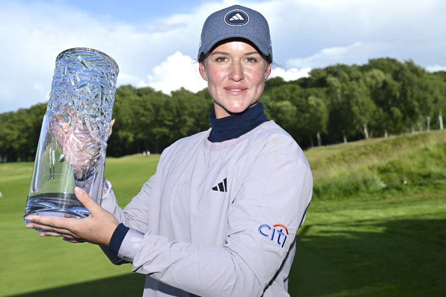 Linn Grant raises the trophy after winning the Scandinavian Mixed