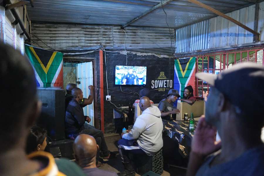 Springboks fans gather around a television to watch their beloved team.