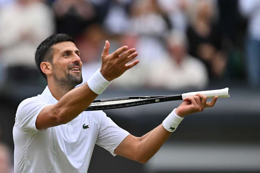 Serbia's Novak Djokovic imitates playing the violin with his racquet