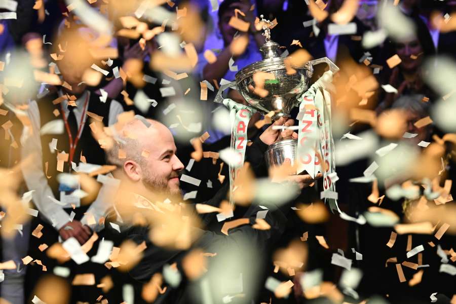 Belgium's Luca Brecel celebrates with the trophy after winning against England's Mark Selby in their World Championship Snooker final