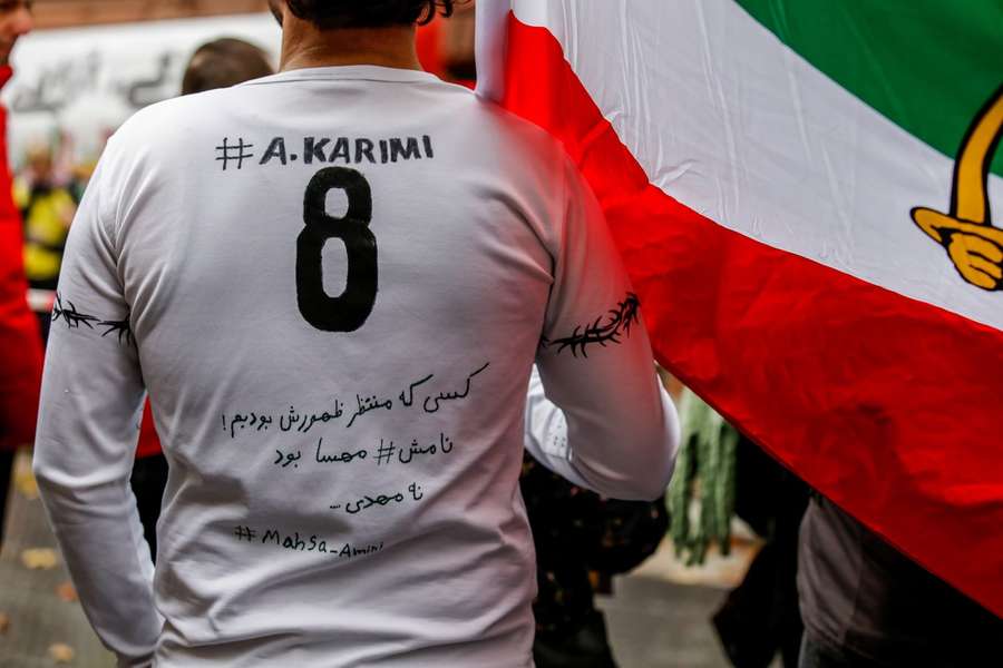 Un protestatar iranian din Frankfurt și-a scris pe bluză un mesaj de susținere transmis de fostul fotbalist Ali Karimi