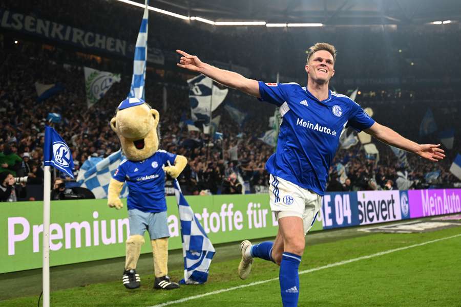 Bulter festeja com a mascote do Schalke em plano de fundo