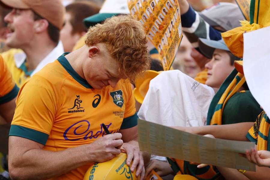 Tane Edmed signs autographs for supporters after the Wallabies' loss to Argentina in Sydney.