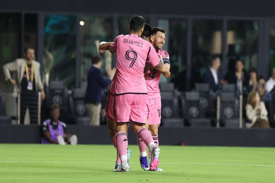 Messi (R) celebrates with Suarez