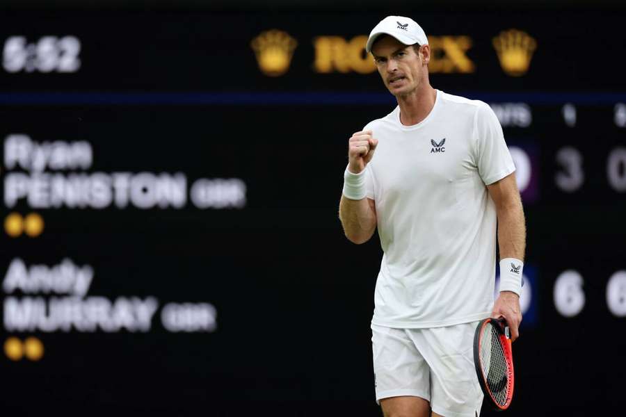 Andy Murray celebrates after beating Ryan Peniston to reach the second round at Wimbledon