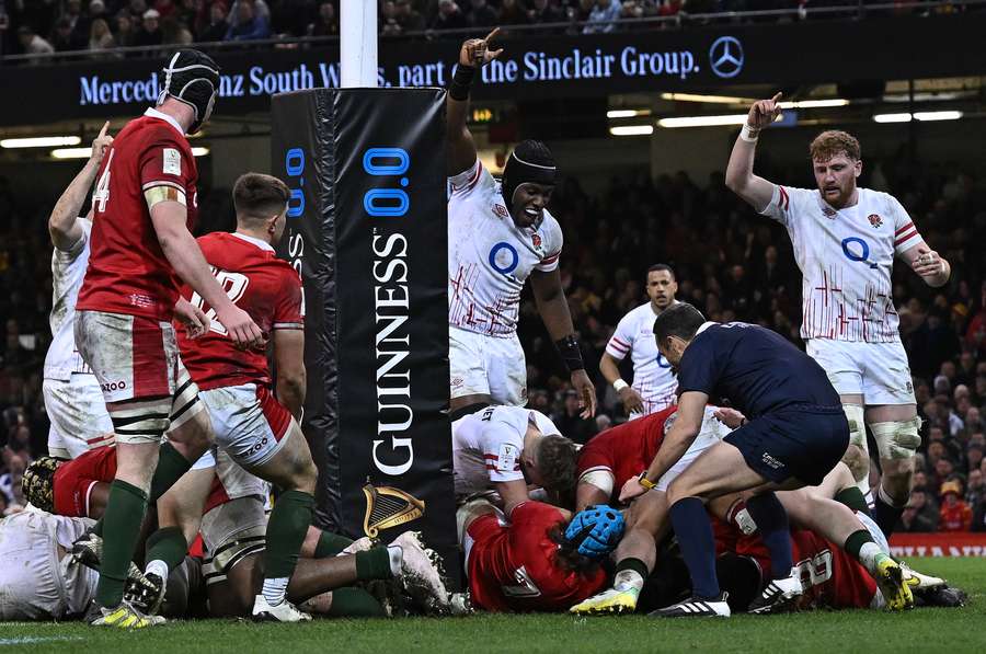 Referee Mathieu Raynal reacts as England's prop Kyle Sinckler scores the team's second try