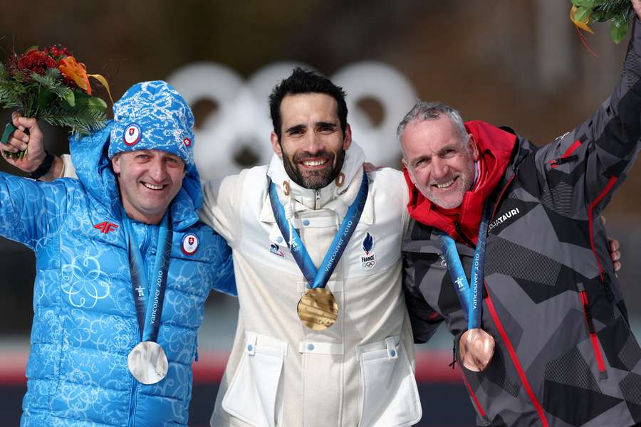 Fourcade v strede na pódiu aj so strieborným Slovákom Hurajtom (vľavo).
