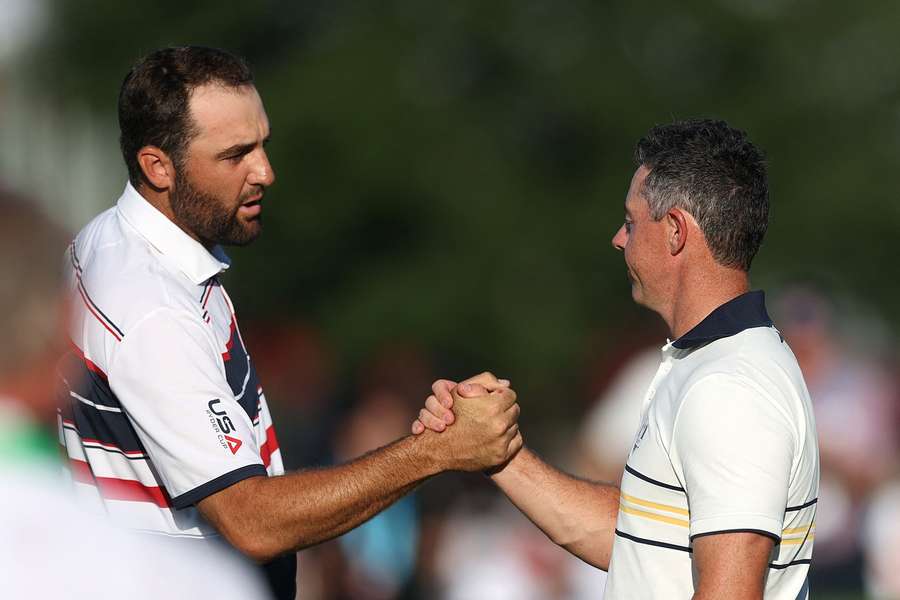 Scheffler (L) and McIlroy shake hands