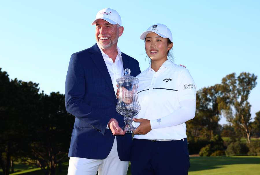 Yin Ruoning of China poses with the winner's trophy