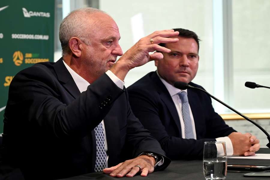 Arnold (L) speaks to the press after extending his contract