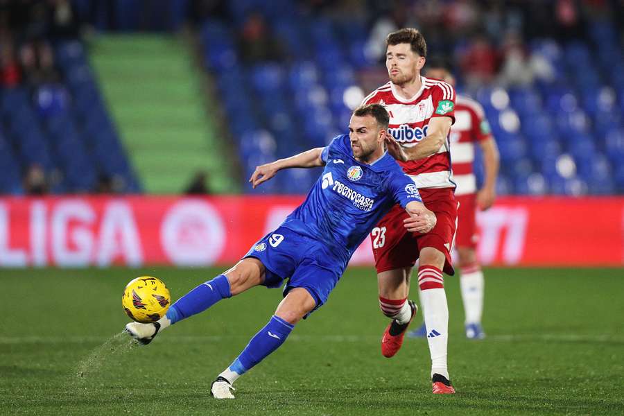 Borja Mayoral of Getafe clears the ball under pressure from Gerard Gumbau of Granada