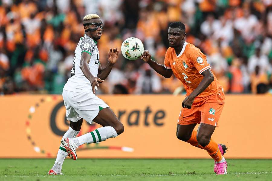 Nigeria forward Victor Osimhen (L) fights for the ball with Ivory Coast defender Ousmane Diomande during the Africa Cup of Nations