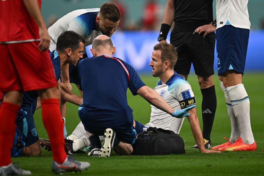 Harry Kane receives medical attention during the Qatar 2022 World Cup Group B football match between England and Iran