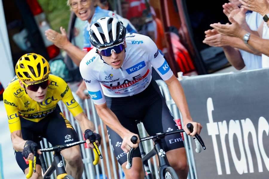 Tadej Pogacar wearing the best young rider's white jersey cycles ahead of Jonas Vingegaard