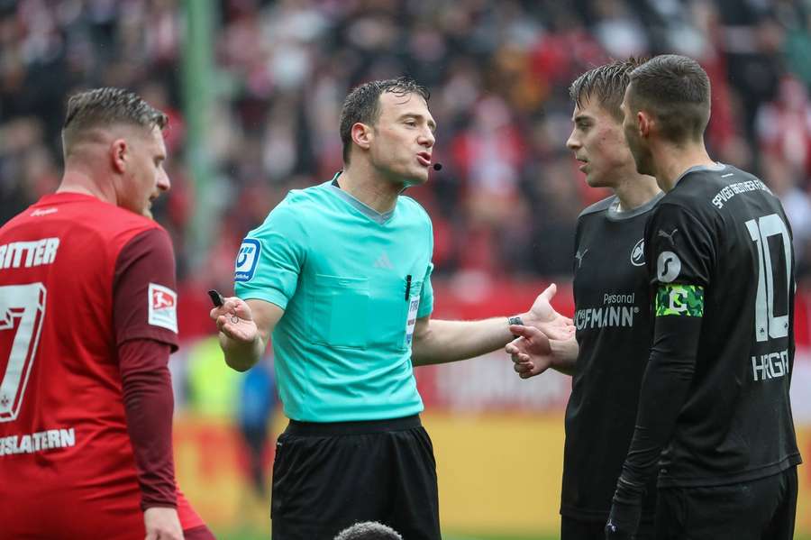 Schiedsrichter Felix Zwayer (M.) wirbt im 2. Bundesliga-Spiel zwischen Kaiserslautern und Fürth um Verständnis für seine Entscheidung.