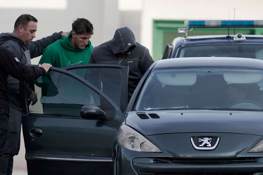 Auradou e Jegou são escoltados para um carro pela polícia argentina