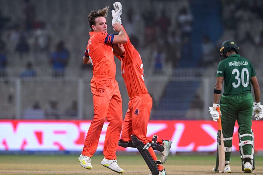 Netherlands' Bas de Leede (L) celebrates with his captain Scott Edwards after taking the wicket of Bangladesh's Mahmudullah (R)