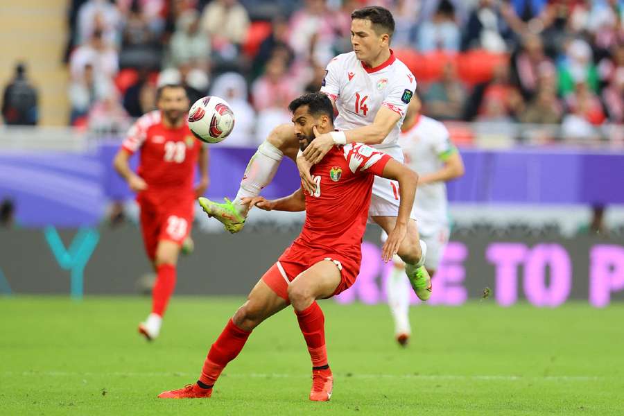 Tajikistan's Alisher Shukurov (R) in action with Jordan's Mousa Tamari