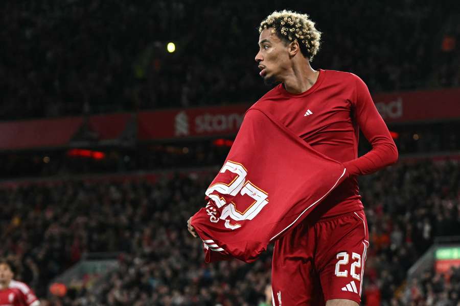 Liverpool's French striker #22 Hugo Ekitike starts to remove his shirt as he celebrates scoring their second goal