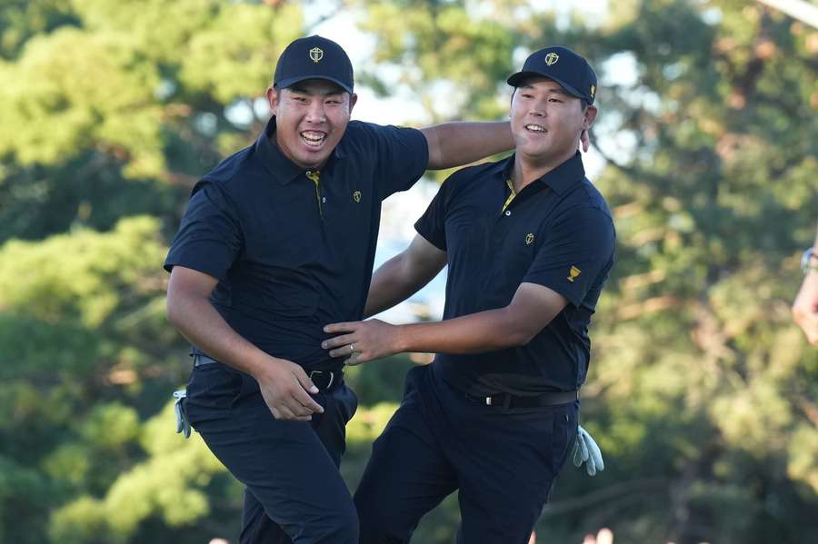 Si Woo Kim and Byeong Hun An celebrate on the 18th hole