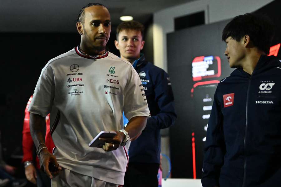 El piloto británico de Mercedes Lewis Hamilton (izq.) sale junto al piloto tailandés de Williams Alexander Albon (detrás) y el piloto japonés de Alpha Tauri Yuki Tsunoda (dcha.) tras una rueda de prensa.