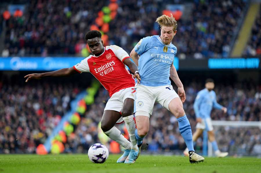 Bukayo Saka of Arsenal battles for possession with Kevin De Bruyne of Manchester City
