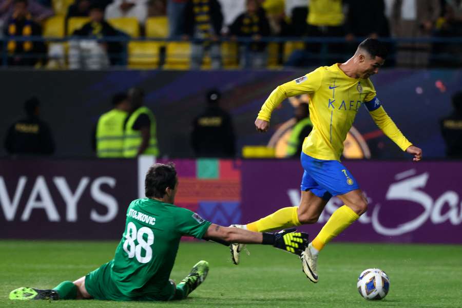 Cristiano Ronaldo runs with the ball past Al Feiha's goalkeeper