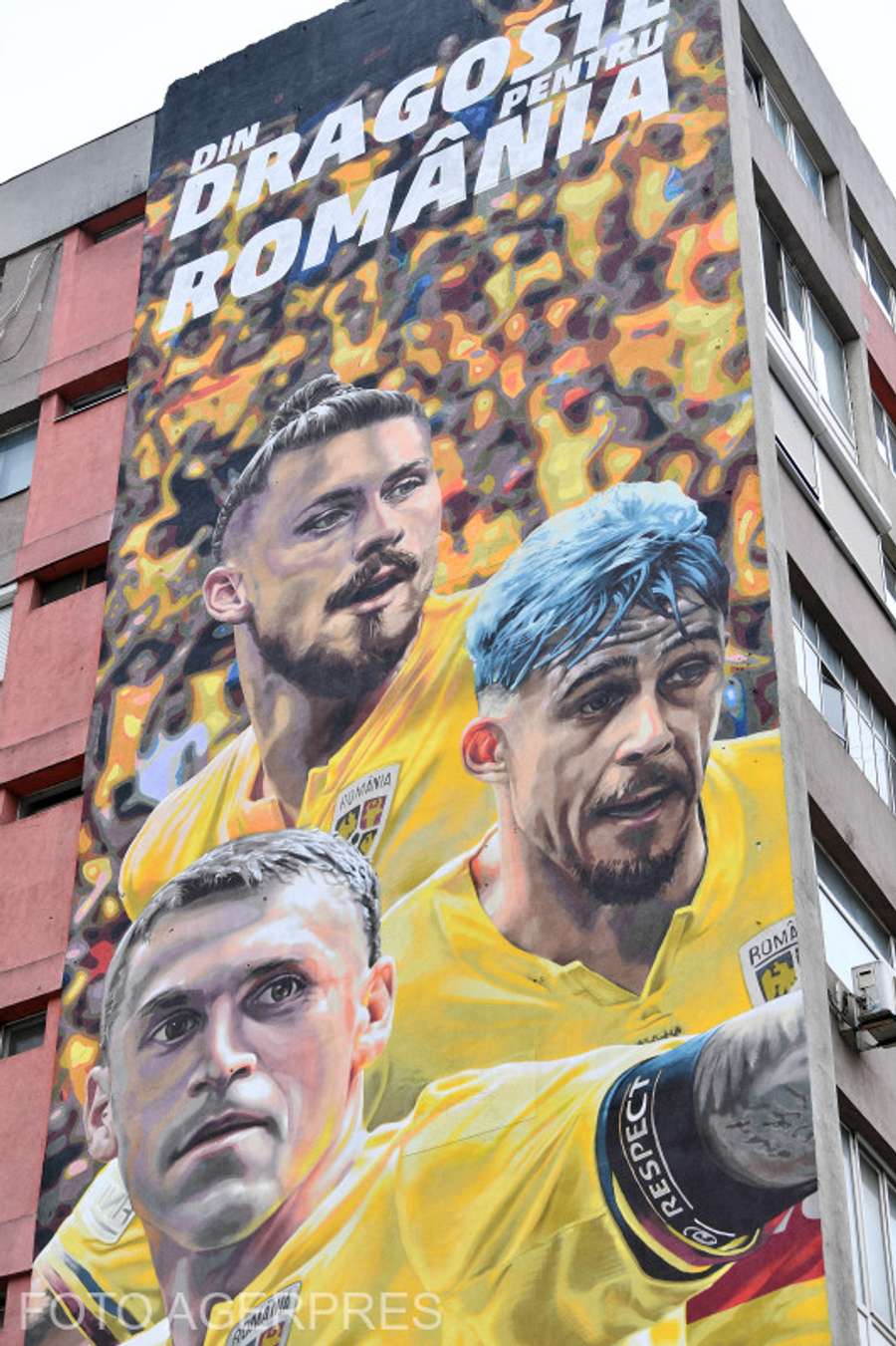 O pictură murală cu trei jucători ai naționalei – Radu Drăgușin, Nicolae Stanciu și Andrei Rațiu – realizată pe fațada unui bloc din centrul Capitalei