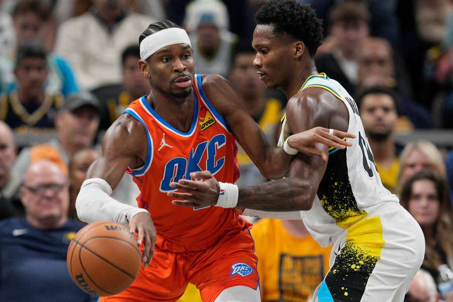 Shai Gilgeous-Alexander of the Oklahoma City Thunder dribbles against Bennedict Mathurin of the Indiana Pacers