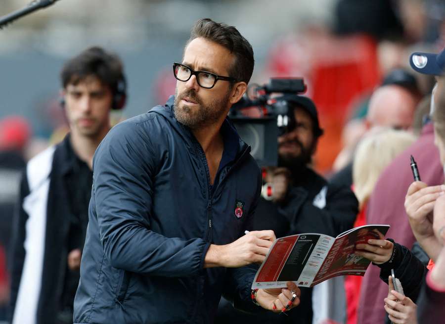 Ryan Reynolds signs autographs before the game on Saturday