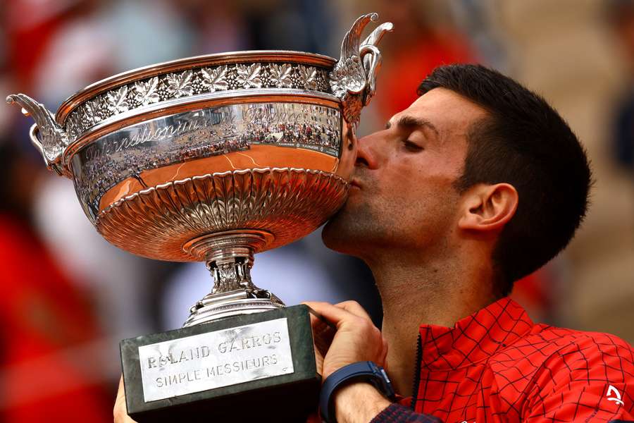 Novak Djokovič si užívá radostný pocit s trofejí za vítězství na French Open.