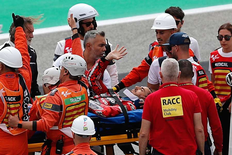 Francesco Bagnaia receives medical attention after crashing during the race
