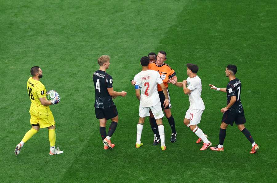 The referee stands between Canada's Richie Laryea and Morocco's Achraf Hakimi after an altercation The referee stands between Canada's Richie Laryea and Morocco's Achraf Hakimi after an altercation