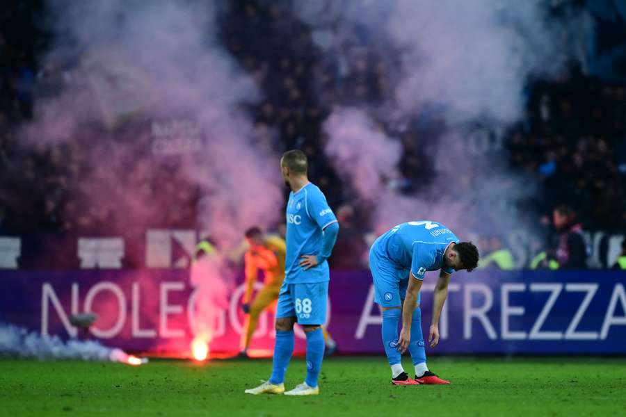 Jogadores do Napoli esperando remoção de sinalizador do gramado do Estádio Olímpico de Turim