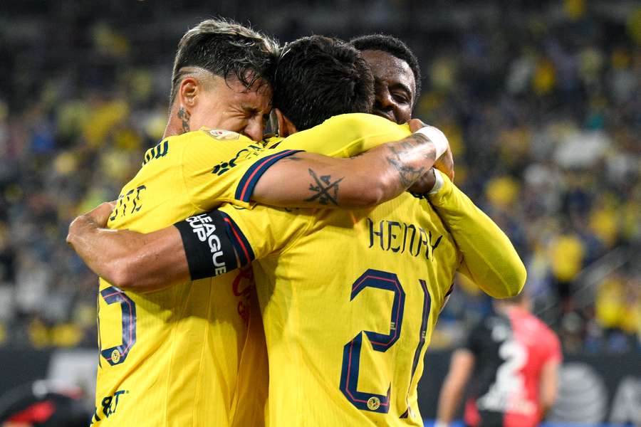 Jugadores del América se abrazan tras un gol.