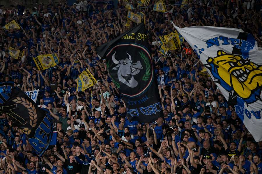 Inter Milan fans cheer as they wait for the start of the match