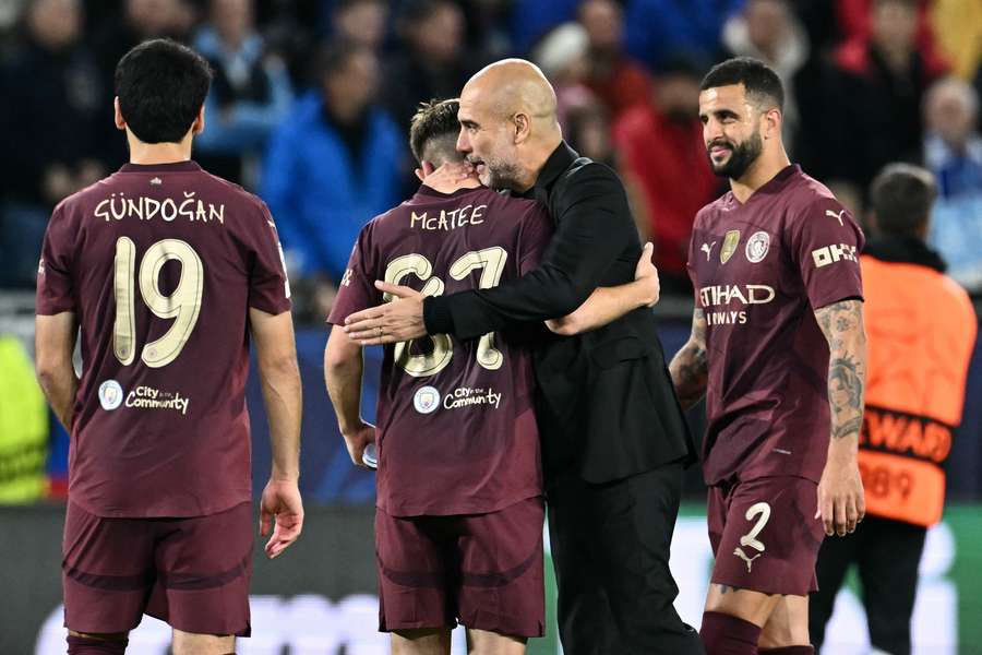 Manchester City manager Pep Guardiola celebrates with James McAtee