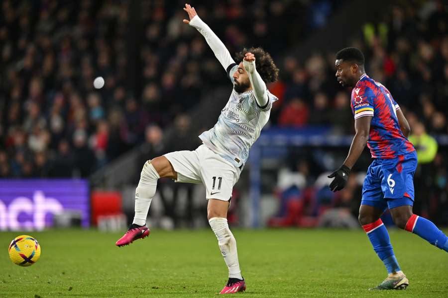 Guehi (R) pushes to win the ball from Liverpool's Salah