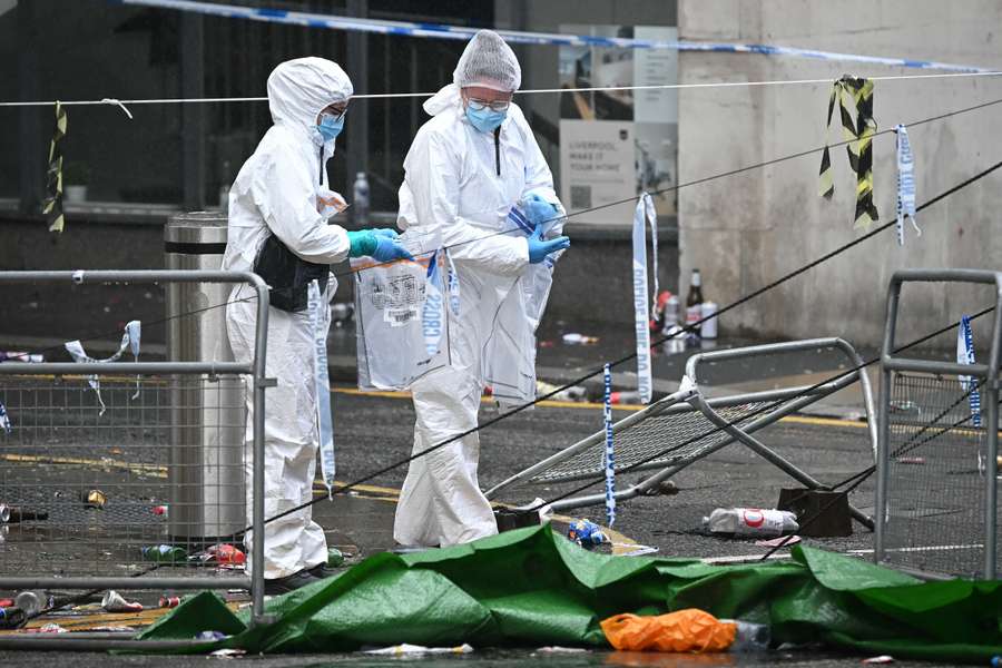 Policyjni kryminalistycy pakują przedmioty do dowodów podczas pracy na miejscu zdarzenia na Water Street w Liverpoolu.
