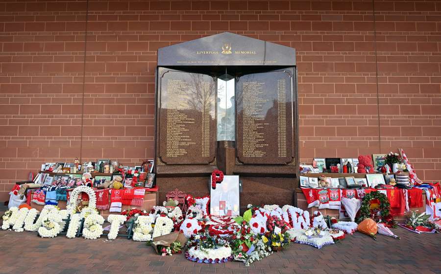 Bloemen, shirts en foto's omringen de eeuwige vlam van het Hillsborough gedenkteken op Anfield in Liverpool