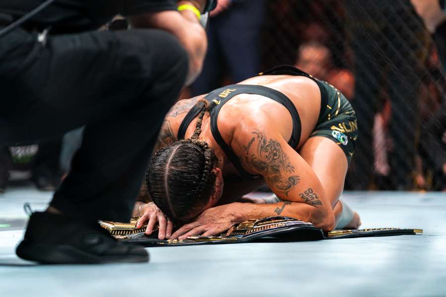 Amanda Nunes a posé un genou sur les ceintures après le combat.