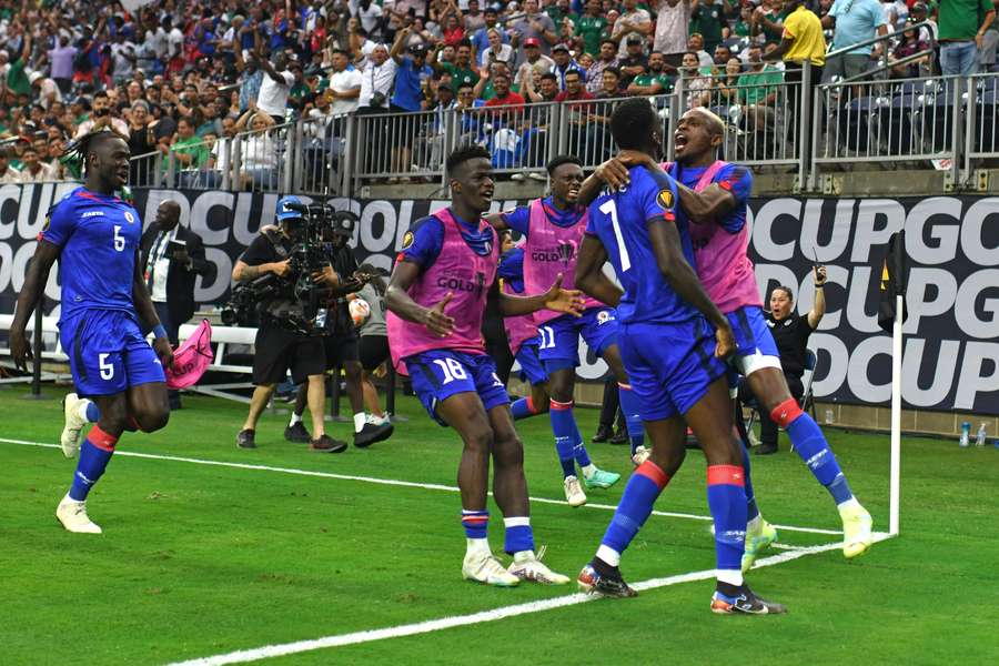 Os jogadores do Haiti comemoram o golo da vitória no final da partida contra o Catar.