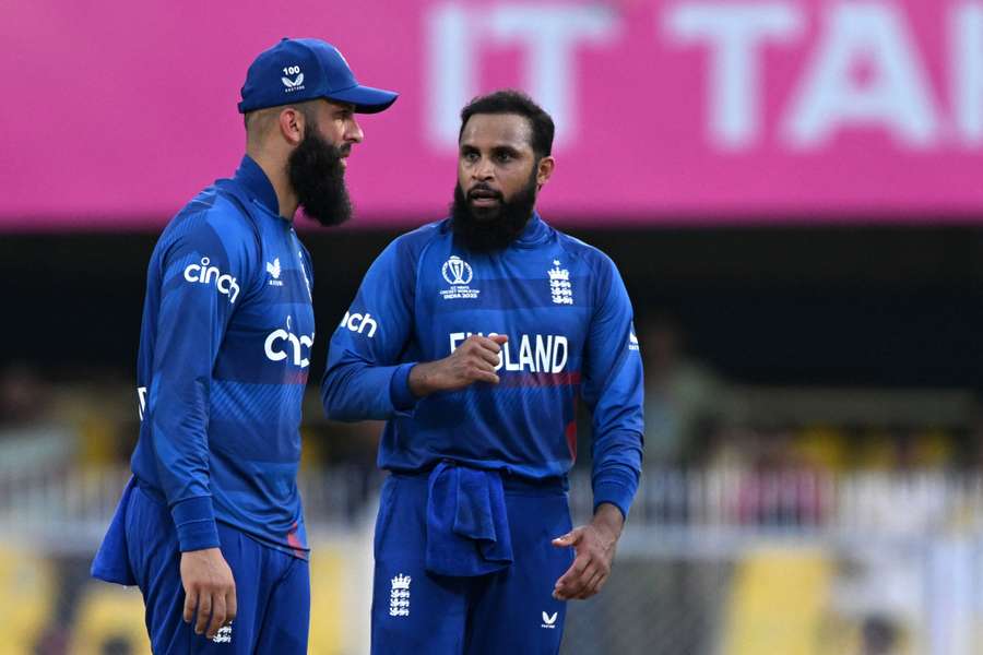 England's Adil Rashid (R) speaks with his teammate Moeen Ali after taking the wicket of Bangladesh's Mahmudullah