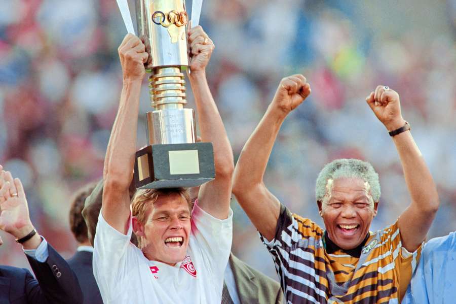 South Africa captain Neil Tovey holds the 1996 AFCON trophy aloft alongside a beaming President Nelson Mandela. South Africa captain Neil Tovey holds the 1996 AFCON trophy aloft alongside a beaming President Nelson Mandela.
