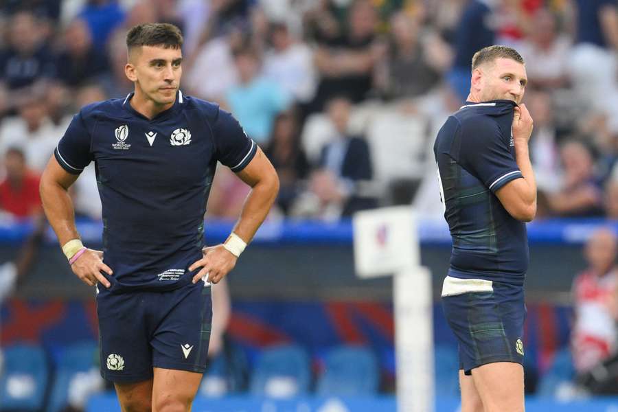 Scotland's fly-half Finn Russell (R) and Scotland's inside centre Cameron Redpath react after their defeat 