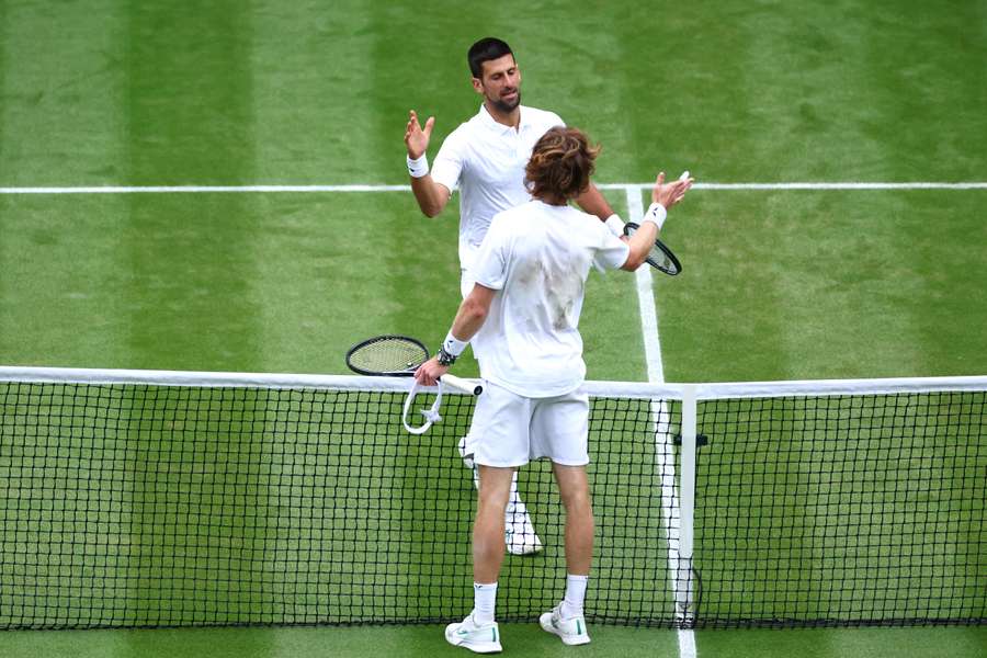 Novak Djokovic and Andrey Rublev shake hands following their contest
